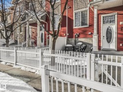 View of side of property with a fenced front yard, a gate, and stone siding - 
