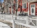 View of side of property with a fenced front yard, a gate, and stone siding - 22 460 Hemingway Rd Nw, Edmonton, AB  - Outdoor With Facade 