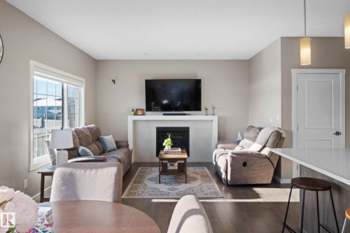 Living room featuring a tiled fireplace and hardwood / wood-style floors - 3904 5 Street, Edmonton, AB - Indoor Photo Showing Living Room With Fireplace