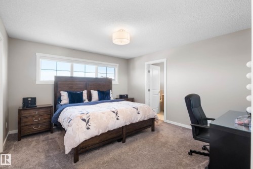 Bedroom with a desk, connected bathroom, carpet floors, and a textured ceiling - 3904 5 Street, Edmonton, AB - Indoor Photo Showing Bedroom