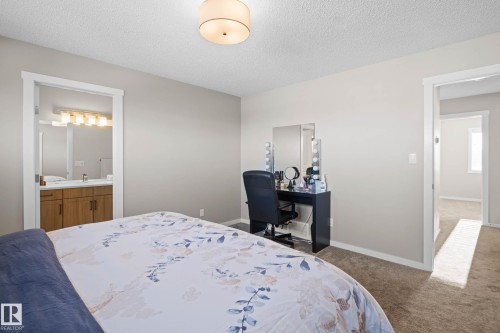 Carpeted bedroom featuring a textured ceiling and ensuite bath - 3904 5 Street, Edmonton, AB - Indoor Photo Showing Bedroom