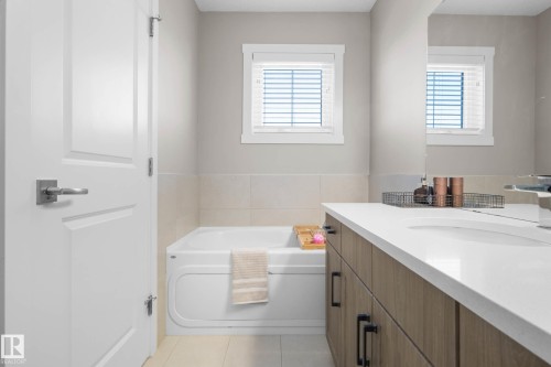 Bathroom with a garden tub, vanity, plenty of natural light, and light tile patterned floors - 3904 5 Street, Edmonton, AB - Indoor Photo Showing Bathroom