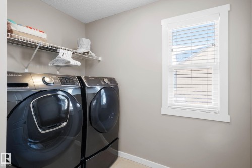 Laundry area featuring washer and dryer and a textured ceiling - 3904 5 Street, Edmonton, AB - Indoor Photo Showing Laundry Room