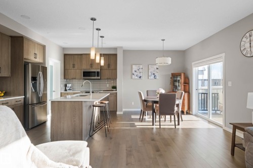 Kitchen with decorative light fixtures, stainless steel appliances, wood finish cabinetry, and a breakfast bar - 3904 5 Street, Edmonton, AB - Indoor