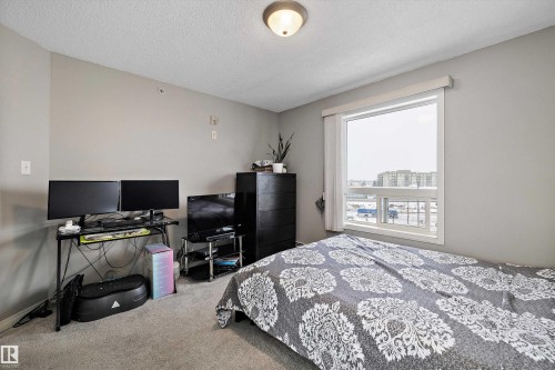 Carpeted bedroom featuring a textured ceiling and baseboards - 2407 320 Clareview Station Drive, Edmonton, AB - Indoor Photo Showing Bedroom