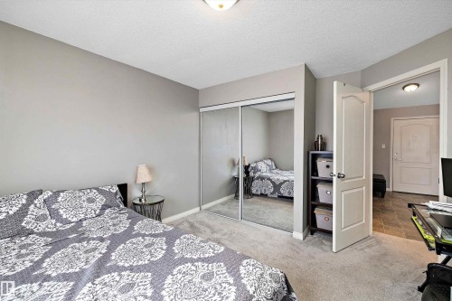 Bedroom featuring light carpet, a textured ceiling, and a closet - 2407 320 Clareview Station Drive, Edmonton, AB - Indoor Photo Showing Bedroom