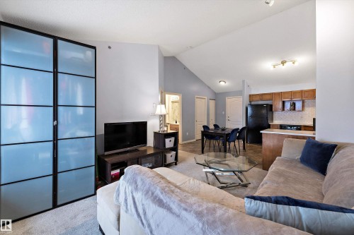 Living room featuring light colored carpet and lofted ceiling - 2407 320 Clareview Station Drive, Edmonton, AB - Indoor Photo Showing Living Room