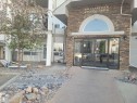 The property features an entrance with a stone facade, glass doors, and an arched window above - 2407 320 Clareview Station Drive, Edmonton, AB  - Outdoor 