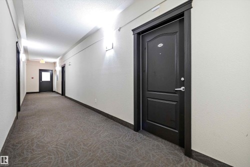 Corridor with dark carpet, a textured ceiling, and a textured wall - 2407 320 Clareview Station Drive, Edmonton, AB - Indoor Photo Showing Other Room