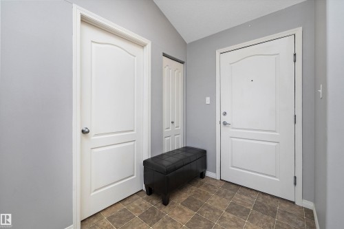 Foyer entrance with lofted ceiling and stone finish flooring - 2407 320 Clareview Station Drive, Edmonton, AB - Indoor Photo Showing Other Room