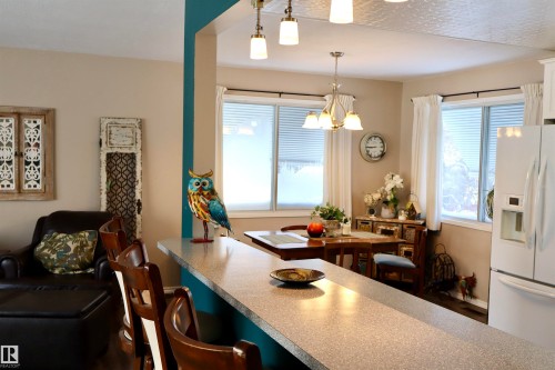 Dining area with healthy amount of natural light and a chandelier - 5220 - 56 Street, Barrhead, AB - Indoor