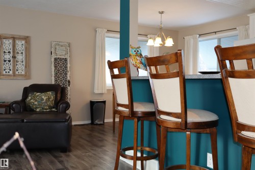Dining area featuring dark wood-type flooring and hanging lights - 5220 - 56 Street, Barrhead, AB - Indoor