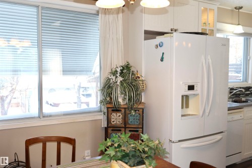 Kitchen featuring white appliances, white cabinets, decorative light fixtures, and glass insert cabinets - 5220 - 56 Street, Barrhead, AB - Indoor Photo Showing Other Room