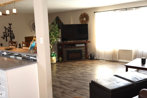 Living area featuring dark wood-style flooring and a fireplace - 5220 - 56 Street, Barrhead, AB - Indoor Photo Showing Living Room