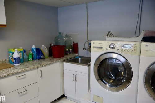 Laundry room featuring cabinet space and washer and clothes dryer - 5220 - 56 Street, Barrhead, AB - Indoor Photo Showing Laundry Room