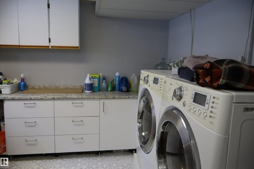 Laundry area featuring washer and dryer and cabinet space - 5220 - 56 Street, Barrhead, AB - Indoor Photo Showing Laundry Room