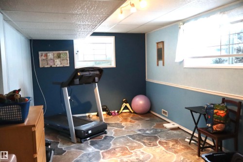 Workout area featuring stone floors and a paneled ceiling - 5220 - 56 Street, Barrhead, AB - Indoor Photo Showing Gym Room