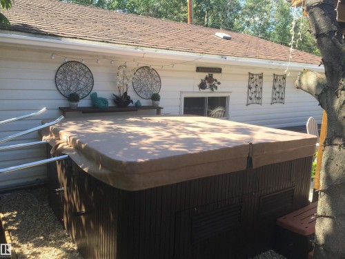 Exterior view of a jacuzzi and a shingled roof - 5220 - 56 Street, Barrhead, AB - Outdoor With Exterior