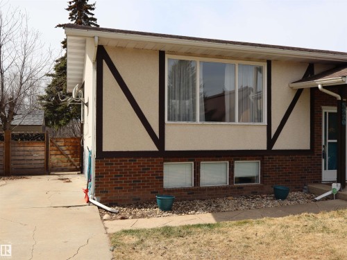 Split-level residence featuring a stucco and brick exterior with decorative dark trim - 5220 - 56 Street, Barrhead, AB - Outdoor With Exterior