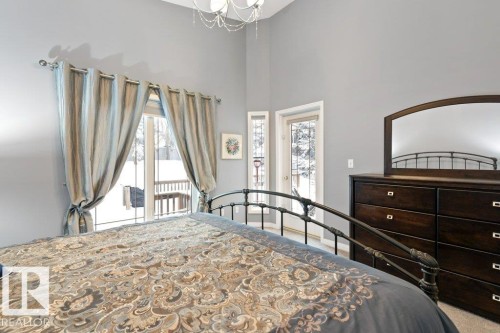 Carpeted bedroom featuring access to exterior, a high ceiling, and suspended lighting - 8 Osborne Close, St. Albert, AB - Indoor Photo Showing Bedroom