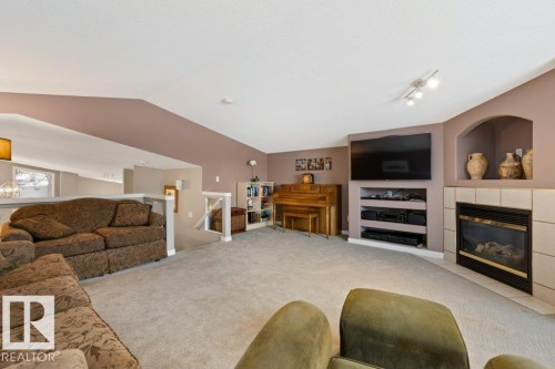Living area featuring built in features, a fireplace, and light carpet - 8 Osborne Close, St. Albert, AB - Indoor Photo Showing Living Room With Fireplace