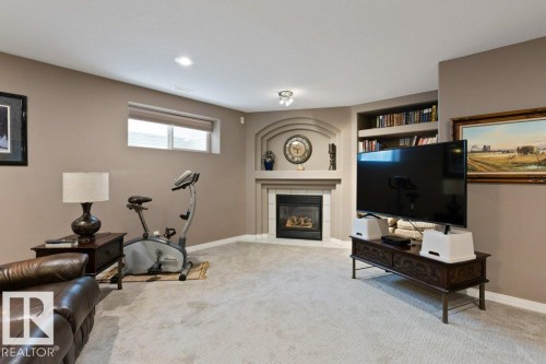 Carpeted living area featuring built in features, a fireplace, and recessed lighting - 8 Osborne Close, St. Albert, AB - Indoor With Fireplace