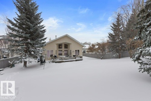 Snow covered rear of property featuring a deck, stucco siding, and a chimney - 8 Osborne Close, St. Albert, AB - Outdoor