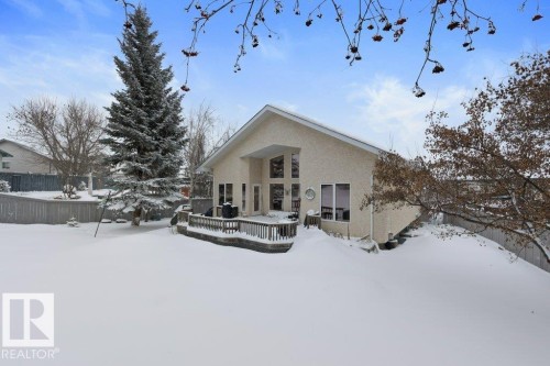 Snow covered house with a wooden deck and stucco siding - 8 Osborne Close, St. Albert, AB - Outdoor