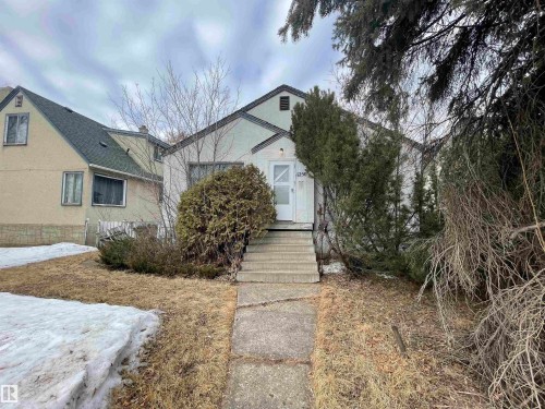 View of property hidden behind natural elements with stucco siding - 11250 72 Avenue, Edmonton, AB - Outdoor
