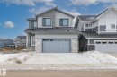 View of front facade with an attached garage, stone siding, and driveway - 132 Edgewater Circle, Leduc, AB  - Outdoor With Facade 