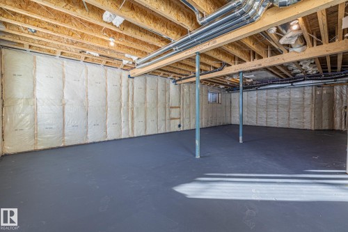 Spacious unfinished basement offering a concrete floor, exposed wooden beams, and insulated walls - 132 Edgewater Circle, Leduc, AB - Indoor Photo Showing Basement