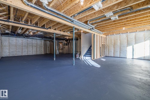 Spacious unfinished basement with painted concrete flooring and exposed wooden joists and ductwork - 132 Edgewater Circle, Leduc, AB - Indoor Photo Showing Basement