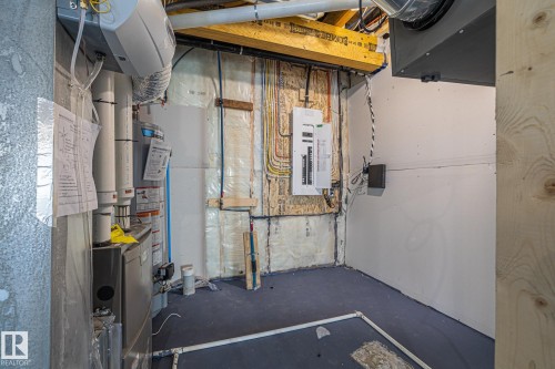 The utility area features exposed ceiling joists, visible electrical wiring, and a modern electrical panel - 132 Edgewater Circle, Leduc, AB - Indoor Photo Showing Basement