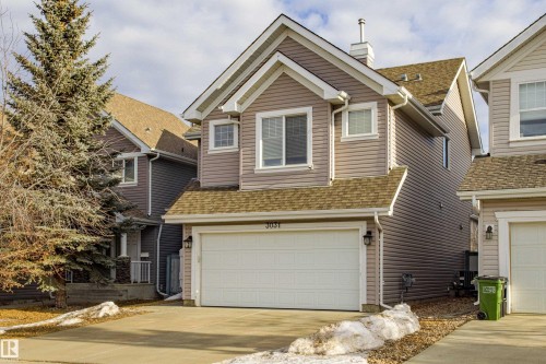 Traditional-style house with driveway, an attached garage, roof with shingles, and a chimney - 3031 Spence Wynd, Edmonton, AB - Outdoor With Facade