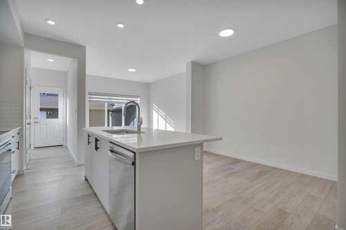Kitchen featuring white cabinetry, light wood-type flooring, dishwasher, an island with sink, and recessed lighting - 2275 Alces Drive, Edmonton, AB - Indoor Photo Showing Kitchen With Upgraded Kitchen