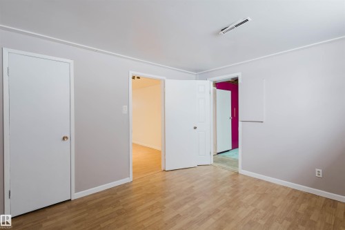 Unfurnished bedroom with light wood-style floors and baseboards - 6048 105B Street Nw, Edmonton, AB - Indoor Photo Showing Other Room