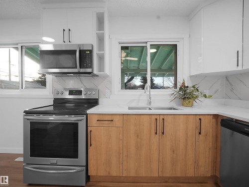 Dual tone kitchen featuring plenty of natural light, stainless steel appliances, modern cabinets, open shelves, and two tone color scheme - 10329 132 Avenue, Edmonton, AB - Indoor Photo Showing Kitchen With Double Sink
