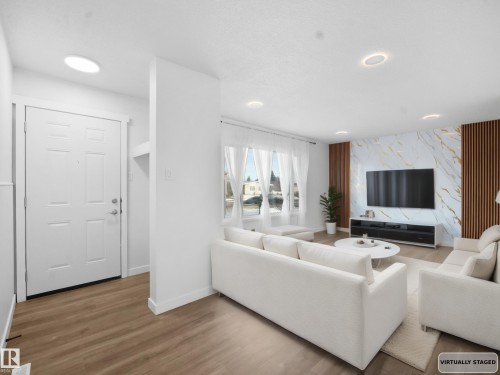 Living room featuring wood finished floors, an accent wall, and recessed lighting - 10329 132 Avenue, Edmonton, AB - Indoor Photo Showing Living Room With Fireplace