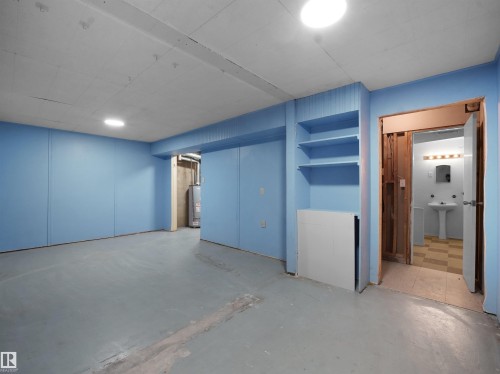 Unfurnished bedroom with concrete flooring and gas water heater - 10329 132 Avenue, Edmonton, AB - Indoor