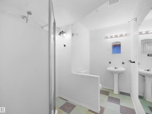 Full bath featuring light floors, a shower stall, and a textured ceiling - 10329 132 Avenue, Edmonton, AB - Indoor