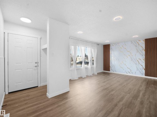 Foyer featuring an accent wall, wallpapered walls, and wood finished floors - 10329 132 Avenue, Edmonton, AB - Indoor Photo Showing Other Room