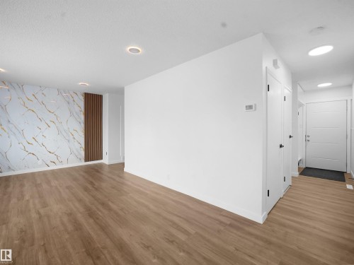 Empty room with an accent wall, wood finished floors, and recessed lighting - 10329 132 Avenue, Edmonton, AB - Indoor Photo Showing Other Room