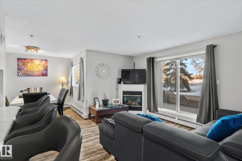 141 17447 98A Avenue, Edmonton, AB - Indoor Photo Showing Living Room With Fireplace