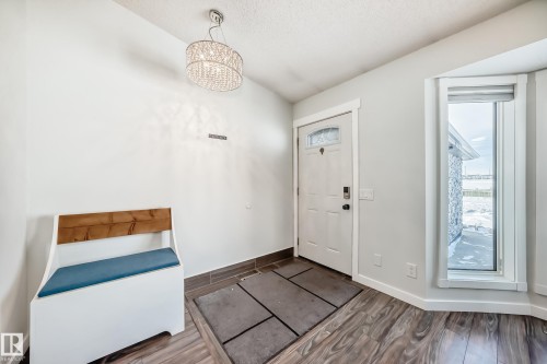 Foyer entrance featuring wood finish floors and a chandelier - 7011 190B Street, Edmonton, AB - Indoor Photo Showing Other Room