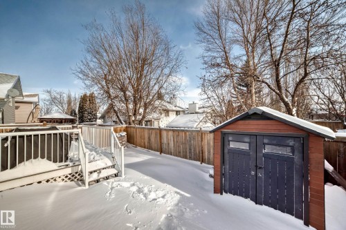 Snowy yard featuring a storage shed, a fenced backyard, and a deck - 7011 190B Street, Edmonton, AB - Outdoor
