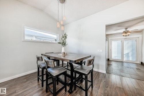 Dining space featuring dark wood-type flooring, lofted ceiling, and a ceiling fan - 7011 190B Street, Edmonton, AB - Indoor Photo Showing Dining Room