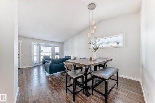 Dining room featuring dark wood-type flooring and vaulted ceiling - 7011 190B Street, Edmonton, AB - Indoor Photo Showing Dining Room