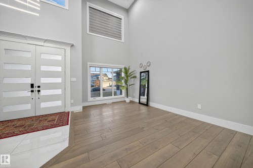 Entrance foyer with french doors, wood tiled floors, and a high ceiling - 4406 Triomphe Close, Beaumont, AB - Indoor Photo Showing Other Room