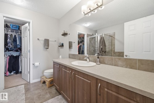 Bathroom featuring a walk in closet, a shower stall, vanity, a textured ceiling, and light tile patterned flooring - 3087 Arthurs Crescent, Edmonton, AB - Indoor Photo Showing Bathroom