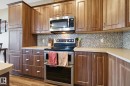 Kitchen featuring stainless steel appliances, light countertops, and wood finish cabinets - 3087 Arthurs Crescent, Edmonton, AB  - Indoor Photo Showing Kitchen With Upgraded Kitchen 